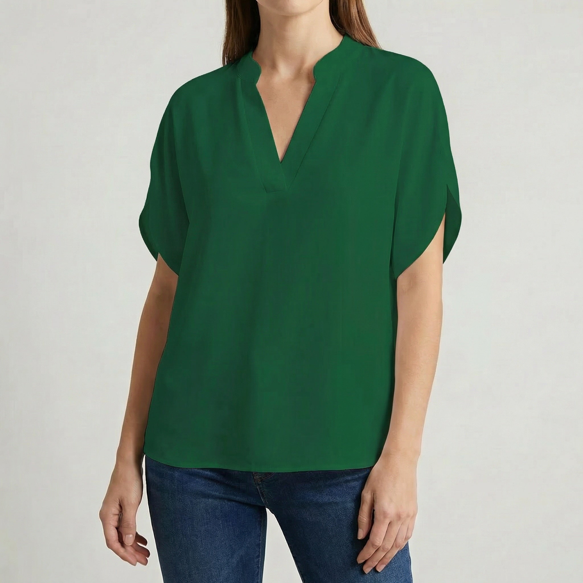 Blouse femme col en V avec manches fendues en vert forêt, portée avec un jean bleu