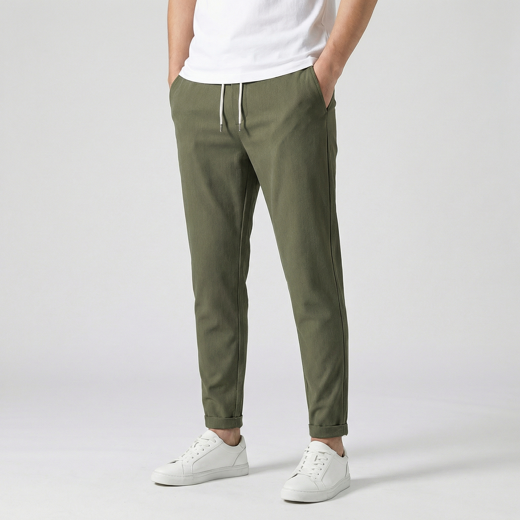 Pantalon jogger slim vert kaki avec cordon de serrage, porté par un homme en t-shirt blanc et baskets blanches