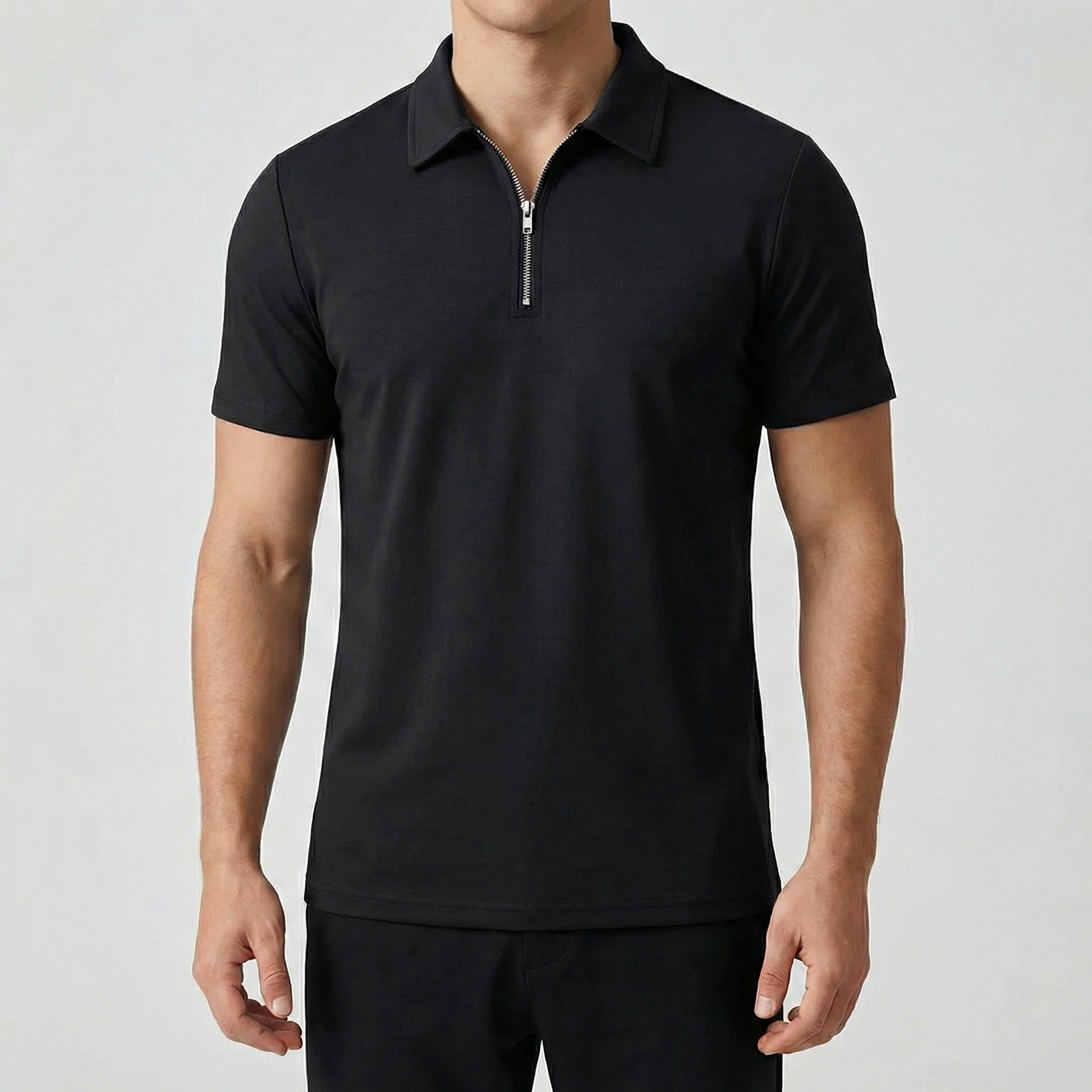 Polo zippé noir à manches courtes, fermeture éclair argentée, coupe slim, porté par un mannequin masculin, fond gris