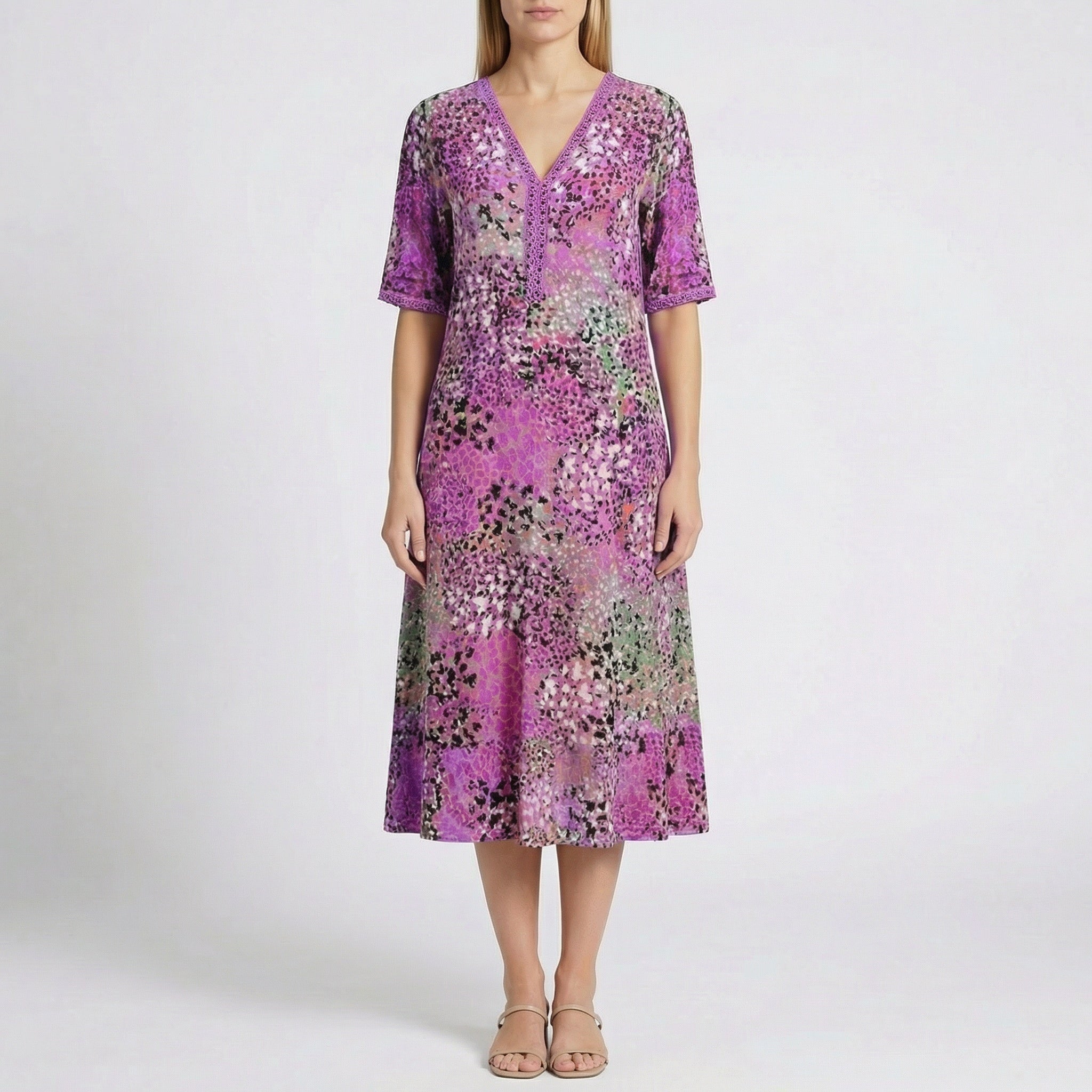 Robe midi Flore Violet à col en V, détails en dentelle et imprimé floral abstrait en violet, rose, vert et noir, portée par un mannequin sur fond gris clair