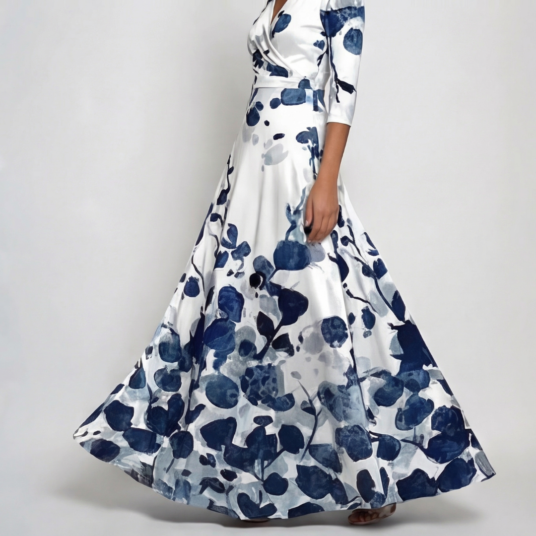 Robe maxi portefeuille à manches 3/4, fond blanc avec grand imprimé floral bleu marine, col V croisé, jupe évasée ample, vue de face
