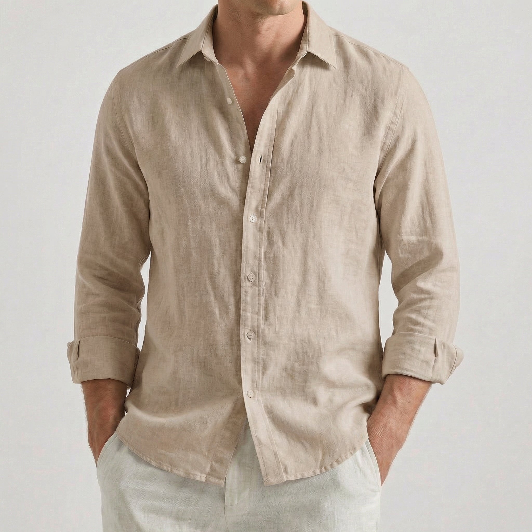 Chemise homme en lin à manches longues et col rabattu, coloris kaki, portée par un mannequin masculin dans une pose décontractée sur fond gris clair