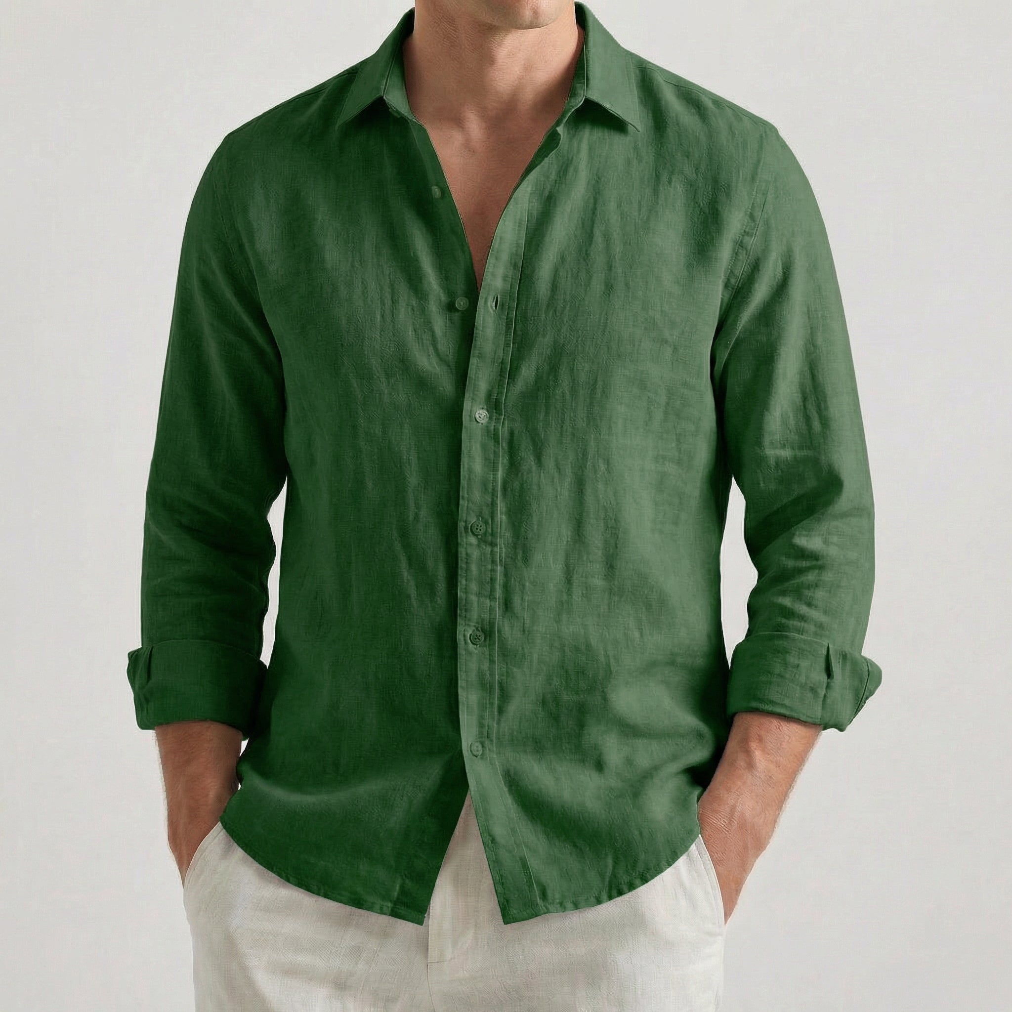 Chemise homme en lin à manches longues et col rabattu, coloris vert foncé, portée par un mannequin masculin dans une pose décontractée sur fond gris clair