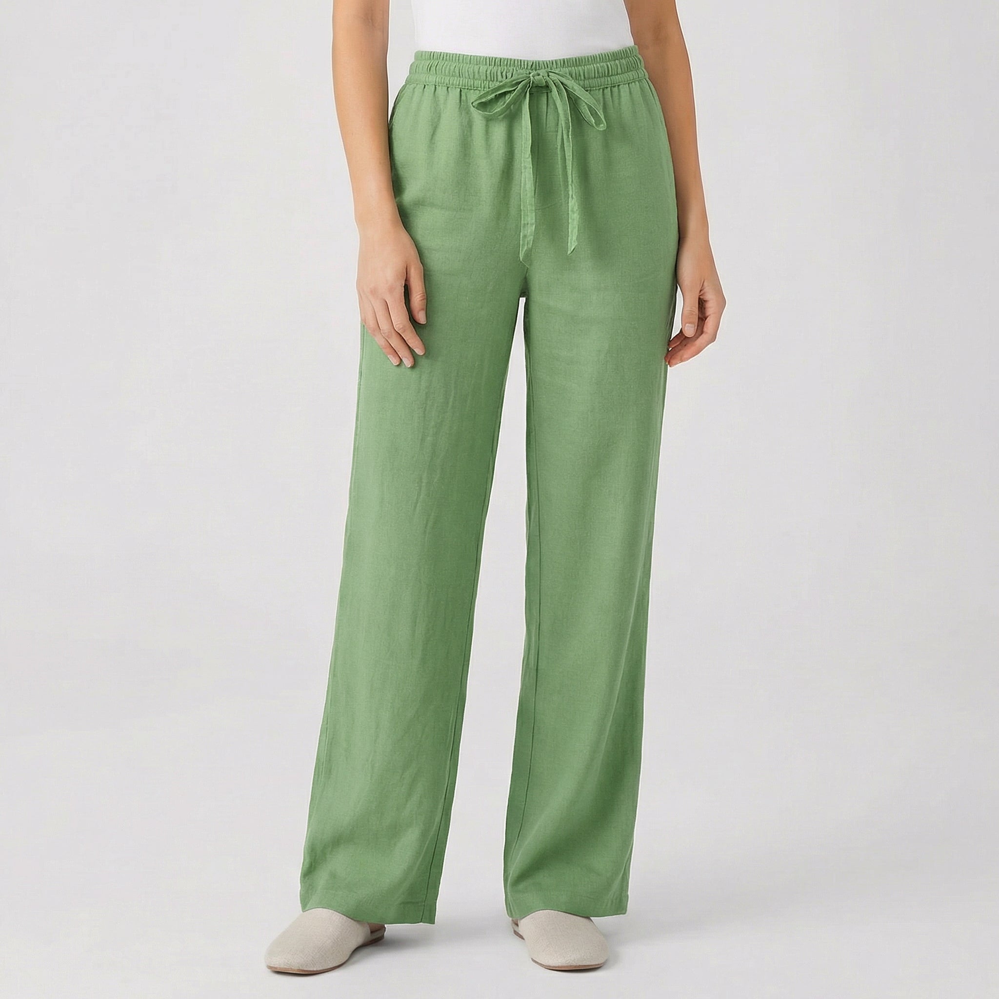 Pantalon fluide femme vert avec taille élastique et cordon, coupe droite, porté par mannequin, fond gris clair
