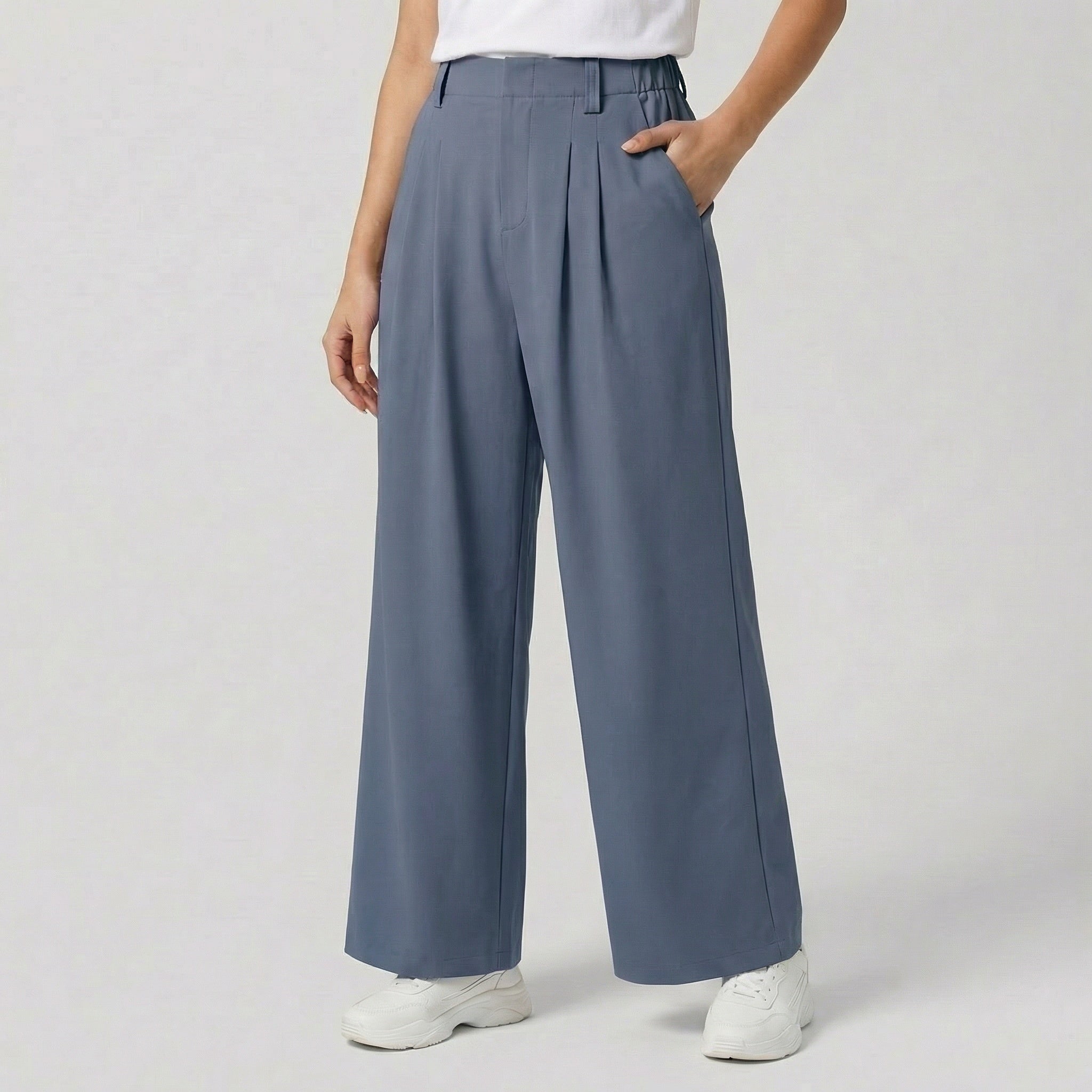 Pantalon large taille haute à plis plats, coloris bleu ardoise, avec ceinture élastiquée, poches latérales et jambes amples — coupe fluide et élégante