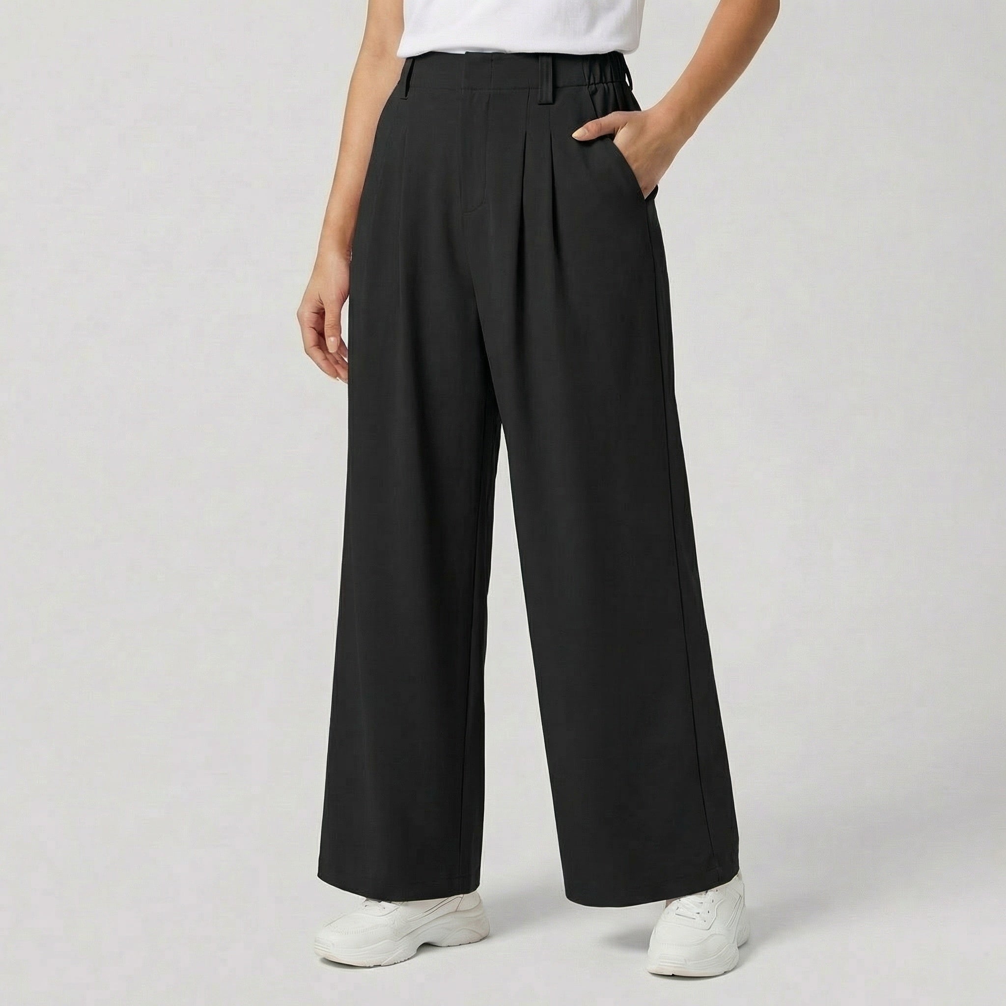 Pantalon large taille haute à plis plats, coloris noir, avec ceinture élastiquée, poches latérales et jambes amples — coupe fluide et élégante