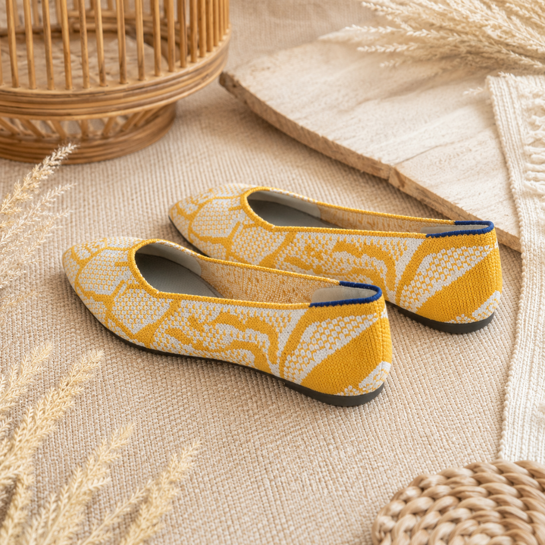 Vue arrière des ballerines jaunes montrant le liseré bleu au talon et la semelle sombre