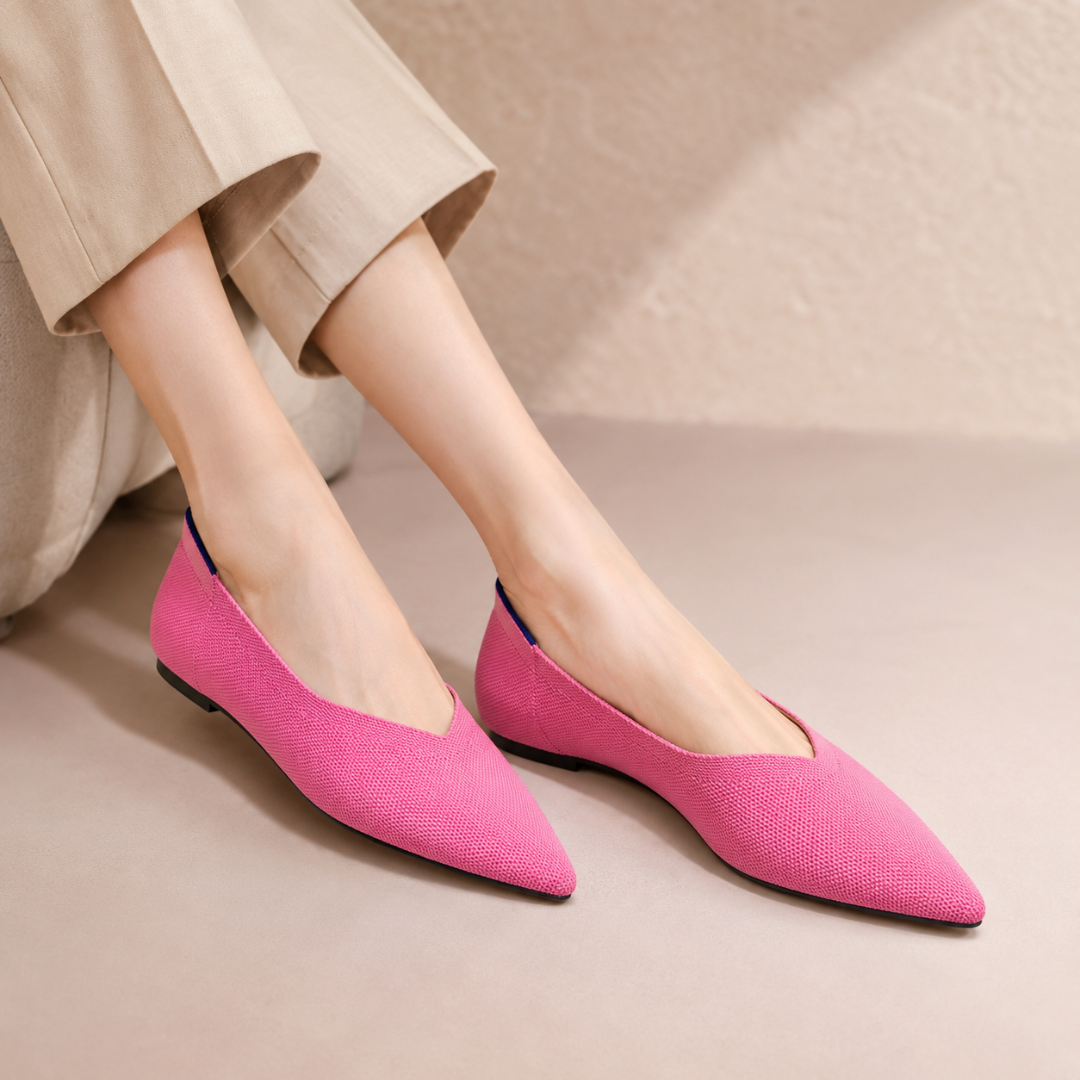 Ballerines rose foncé à bout pointu portées avec un pantalon beige, découpe latérale visible