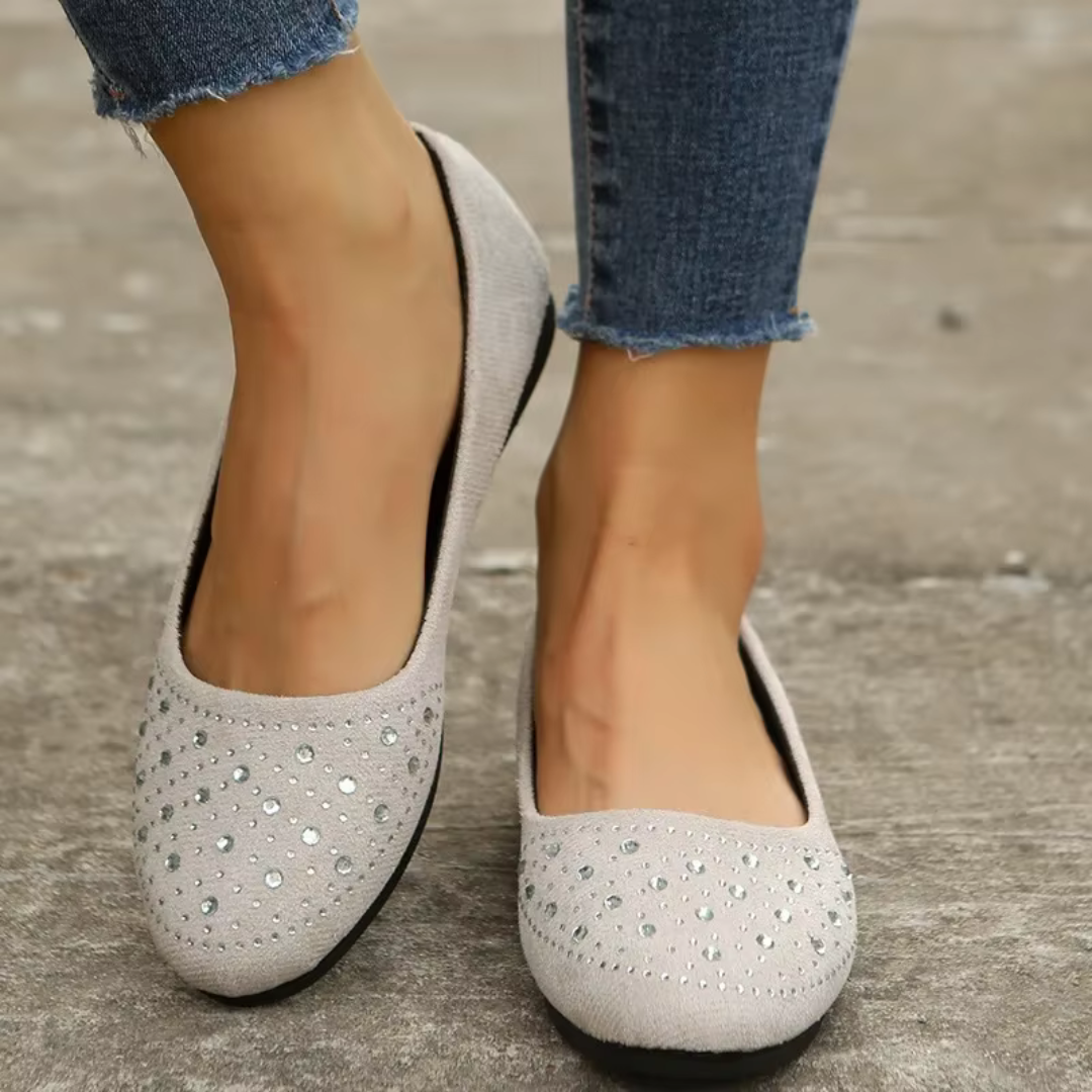 Ballerines blanches à enfiler avec strass sur le bout, portées avec un pantalon bleu