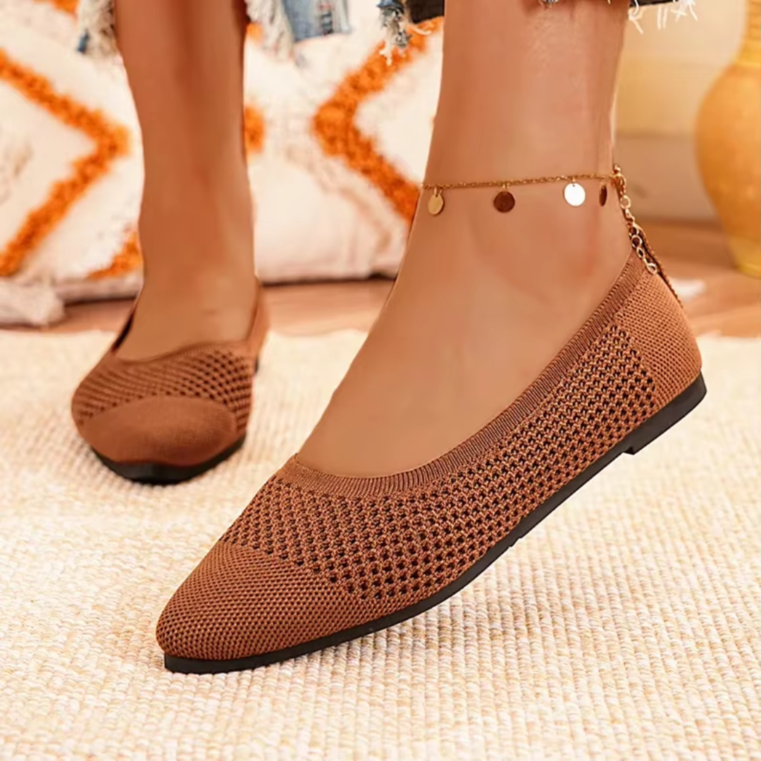 Vue latérale des ballerines brun à bout pointu posées sur tapis beige