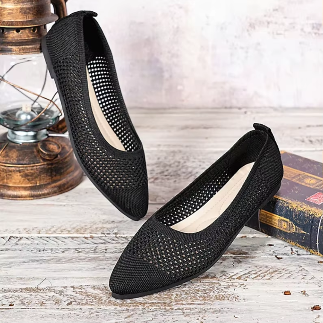 Paire de ballerines noires ajourées bout pointu vue de dessus sur fond bois