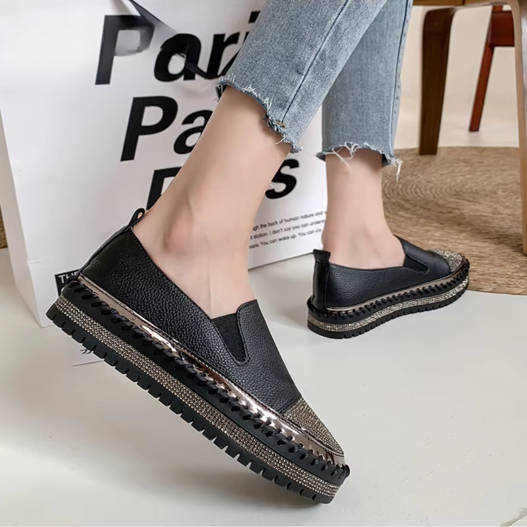 Baskets noires portées de profil, inserts élastiqués et plateforme brillante surpiquée