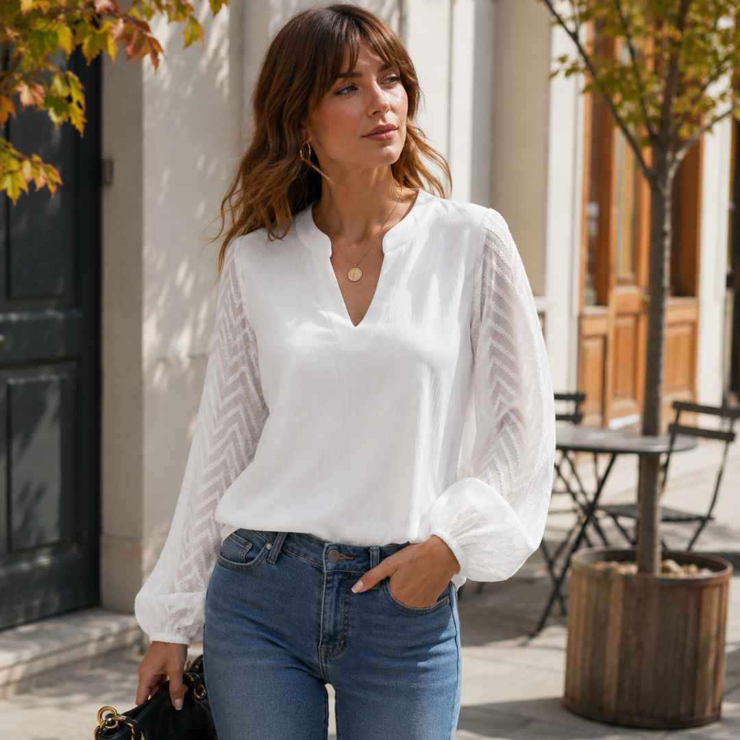 Blouse blanche à col V fendu et manches chevron, portée avec un pantalon bleu clair