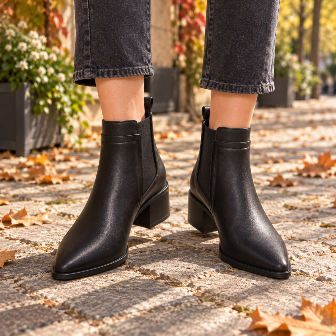 Bottines Chelsea noires portées avec un pantalon gris, talon carré visible