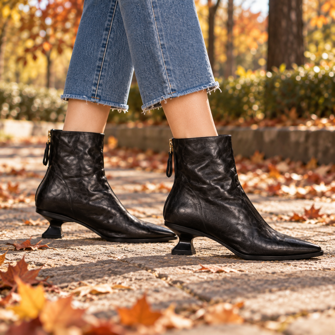 Bottines noires de profil, talon évasé et tirette dorée du zip arrière