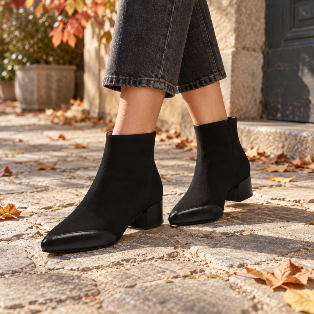 Bottines noires à talon bloc et bout contrastant portées avec un pantalon gris
