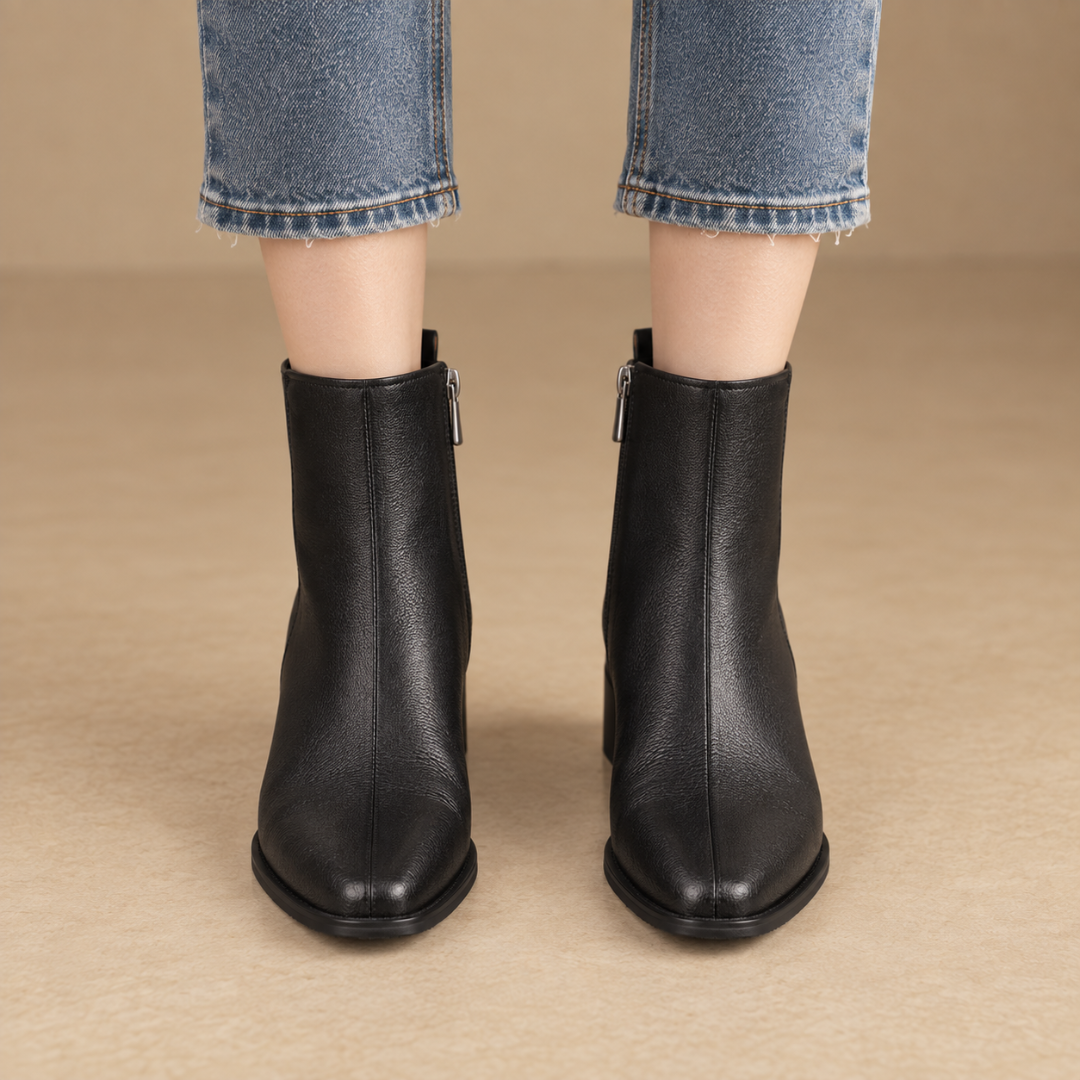Bottines noires vues de face portées avec un pantalon bleu, zips latéraux apparents
