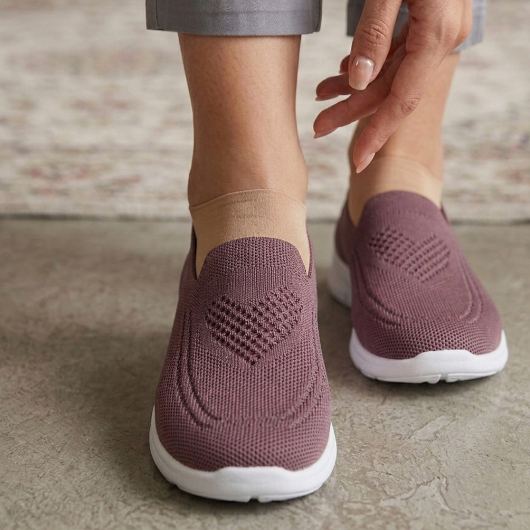 Femme portant des chaussures slip-on roses en maille avec motif cœur ajouré