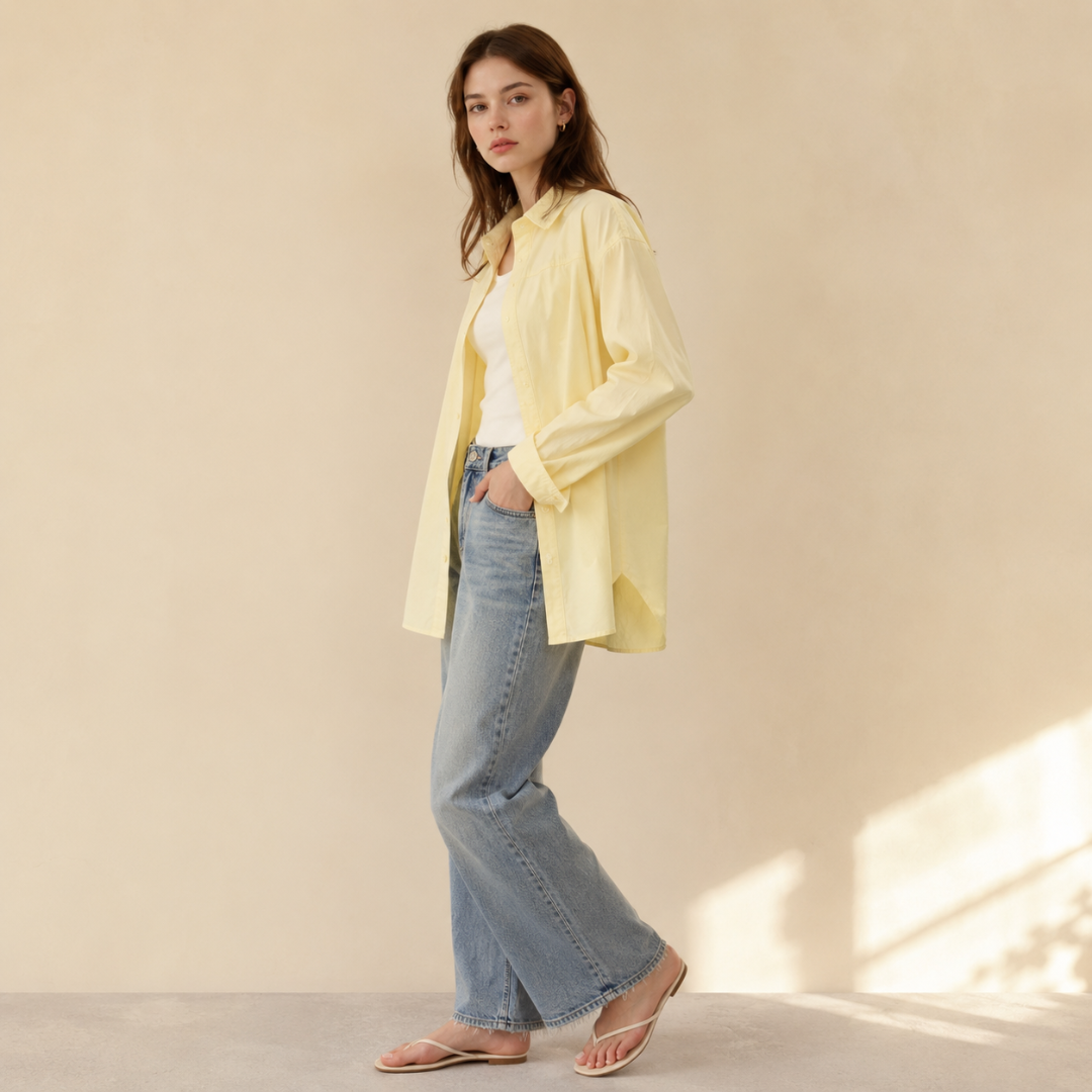 Chemise femme jaune de profil, coupe ample et longueur allongée sur un pantalon bleu clair