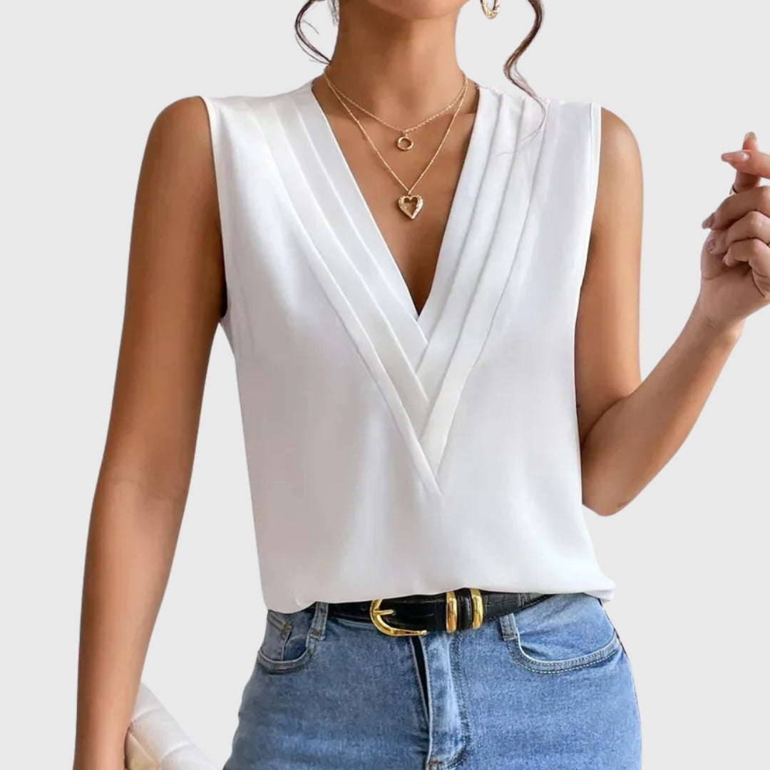 Chemisier femme col V sans manches coloris blanc, porté avec un jean