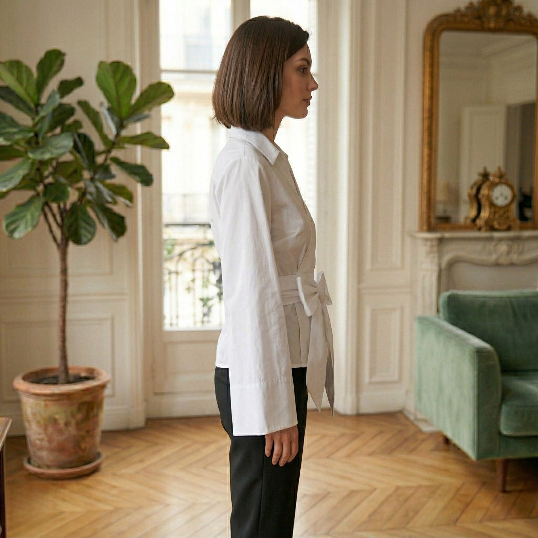 Chemisier femme oversize blanc de profil, ceinture nouée et manches longues