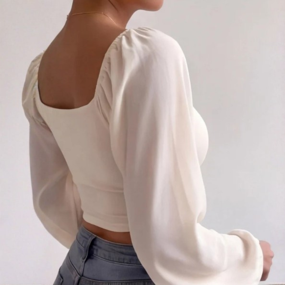 Vue de profil du crop top beige court avec manches longues volumineuses