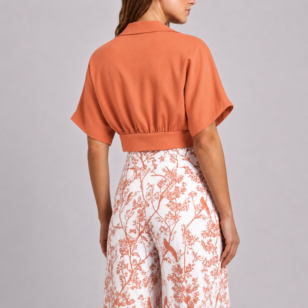 Dos du top court orange avec taille froncée sur pantalon fleuri