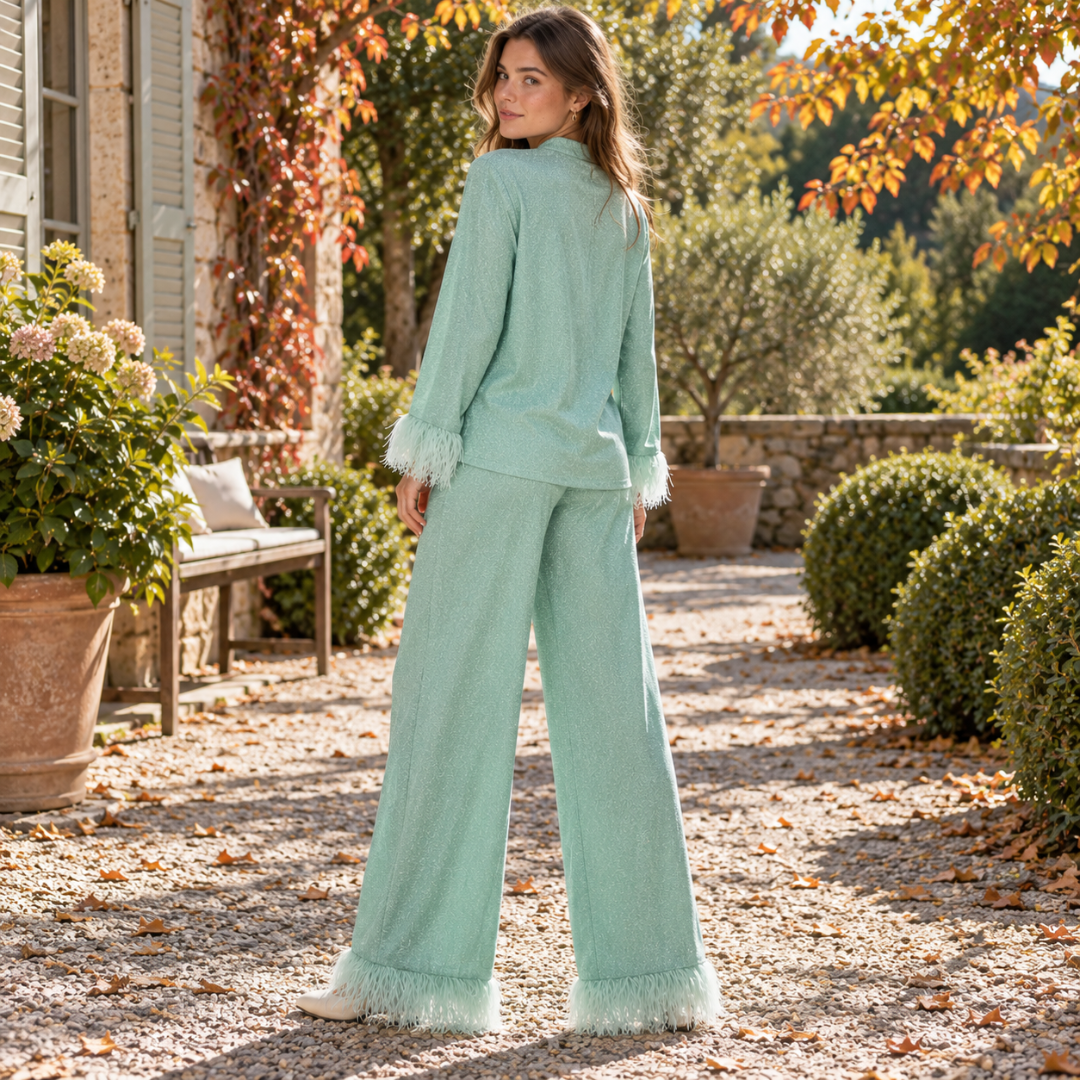 Dos de l'ensemble vert, chemise ample et pantalon large bordé de plumes