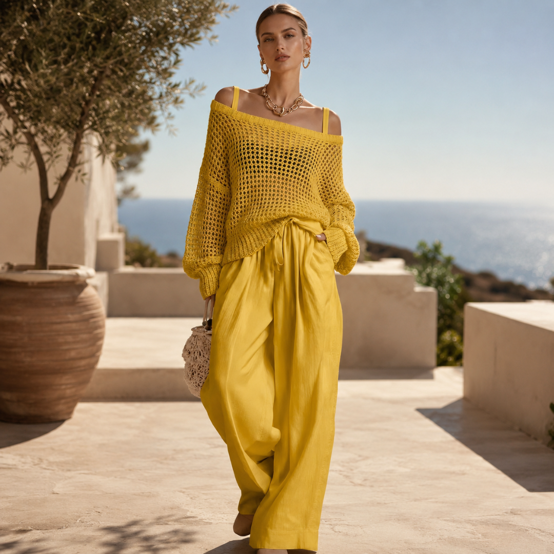 Femme portant un ensemble jaune en maille ajourée et pantalon large sur une terrasse