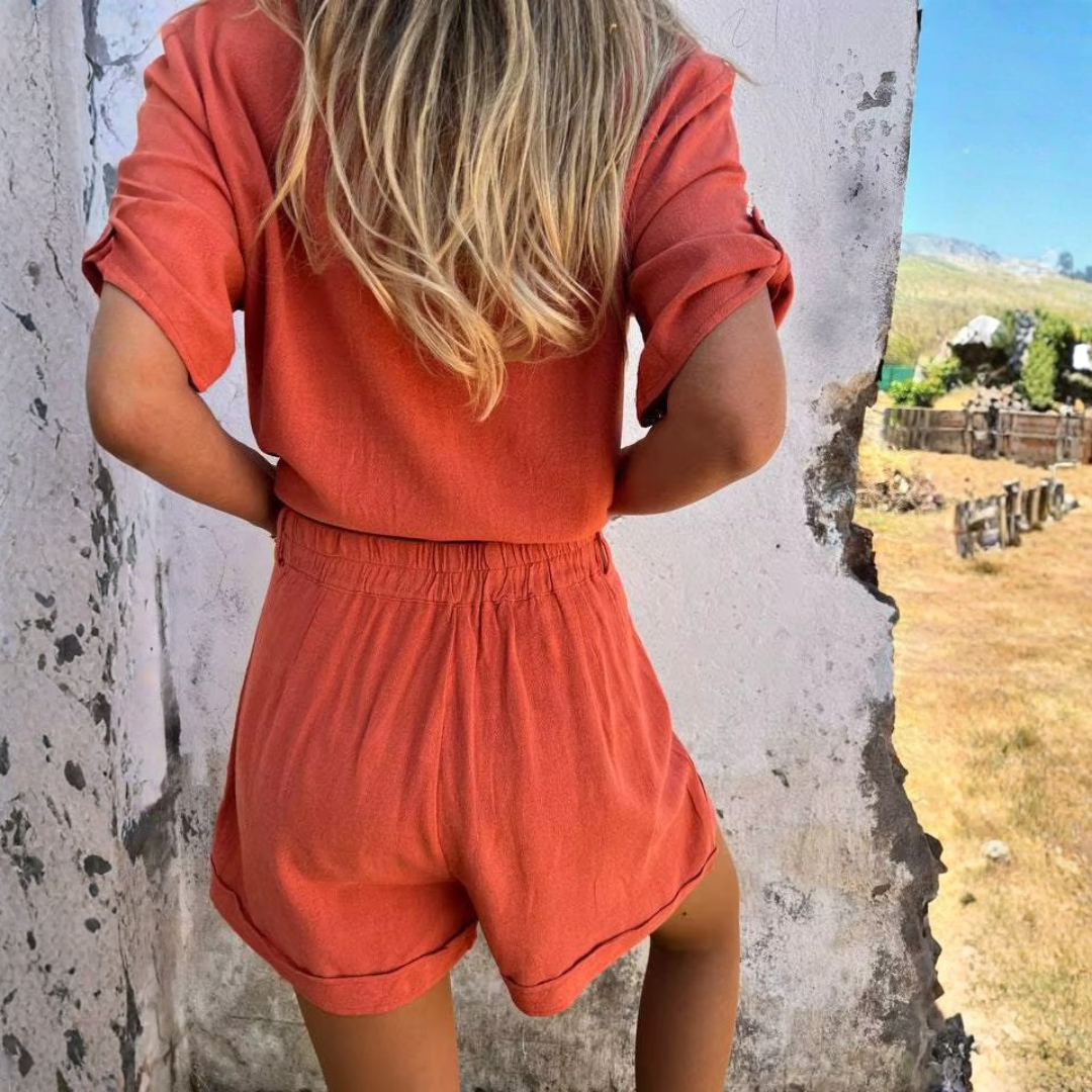 Femme portant l'ensemble Sara orange dans un décor extérieur ensoleillé