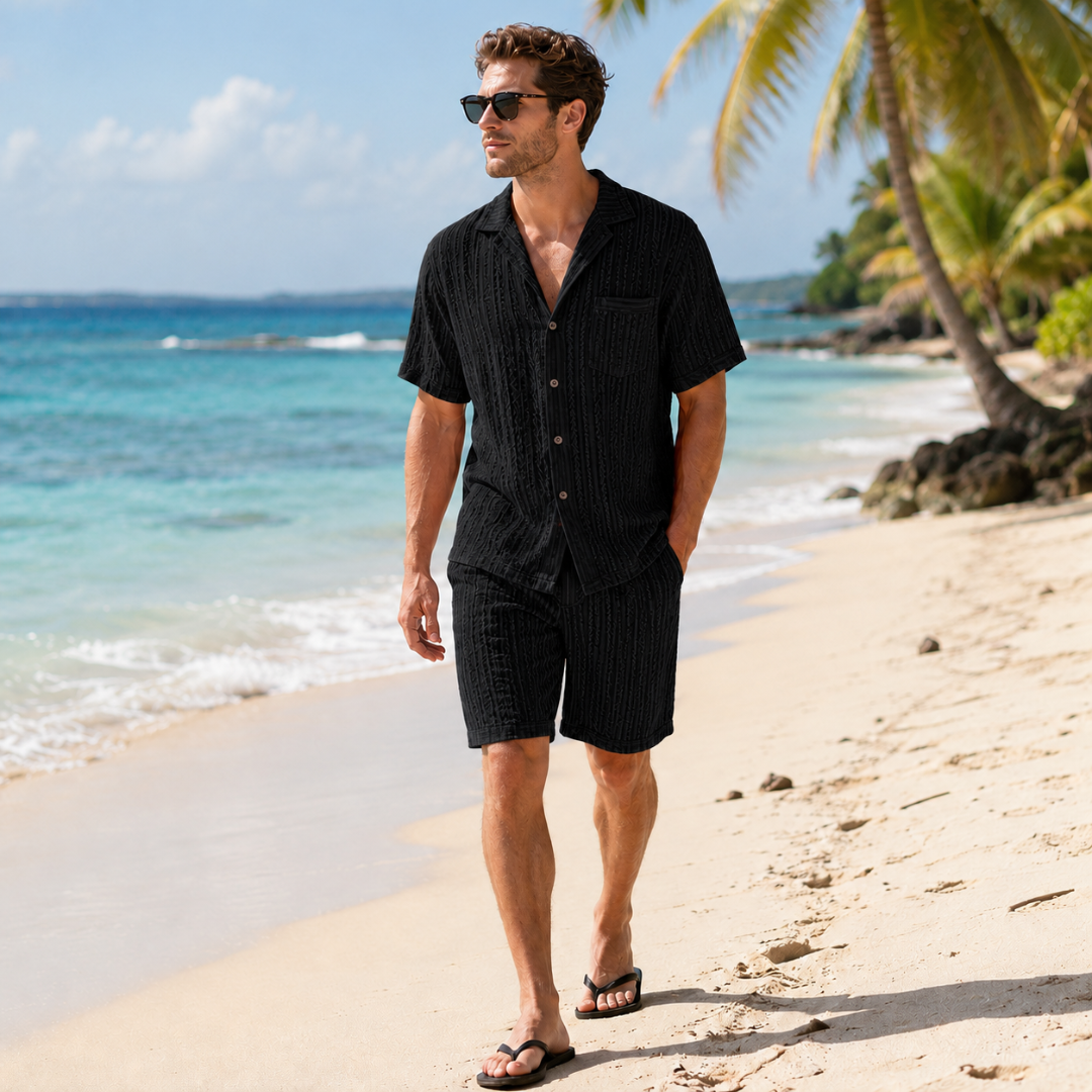 Ensemble homme noir, chemise à col cubain et short assorti texturé en marchant sur le sable