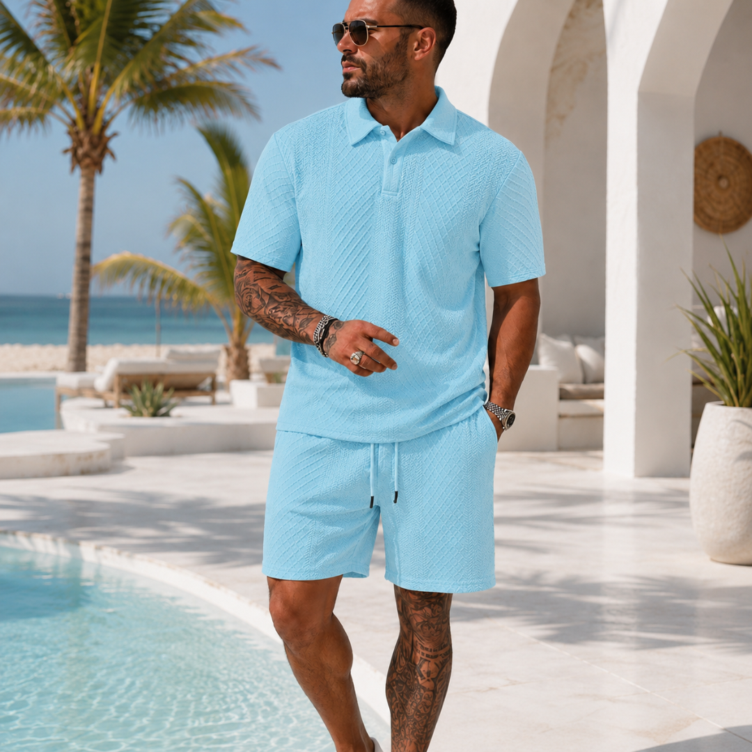 Ensemble homme bleu clair polo texturé et short, porté près d'une piscine avec palmiers