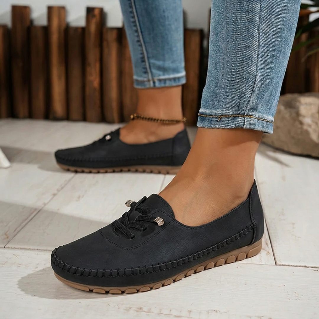 Paire de loafers noirs posée sur sol clair, vue de côté