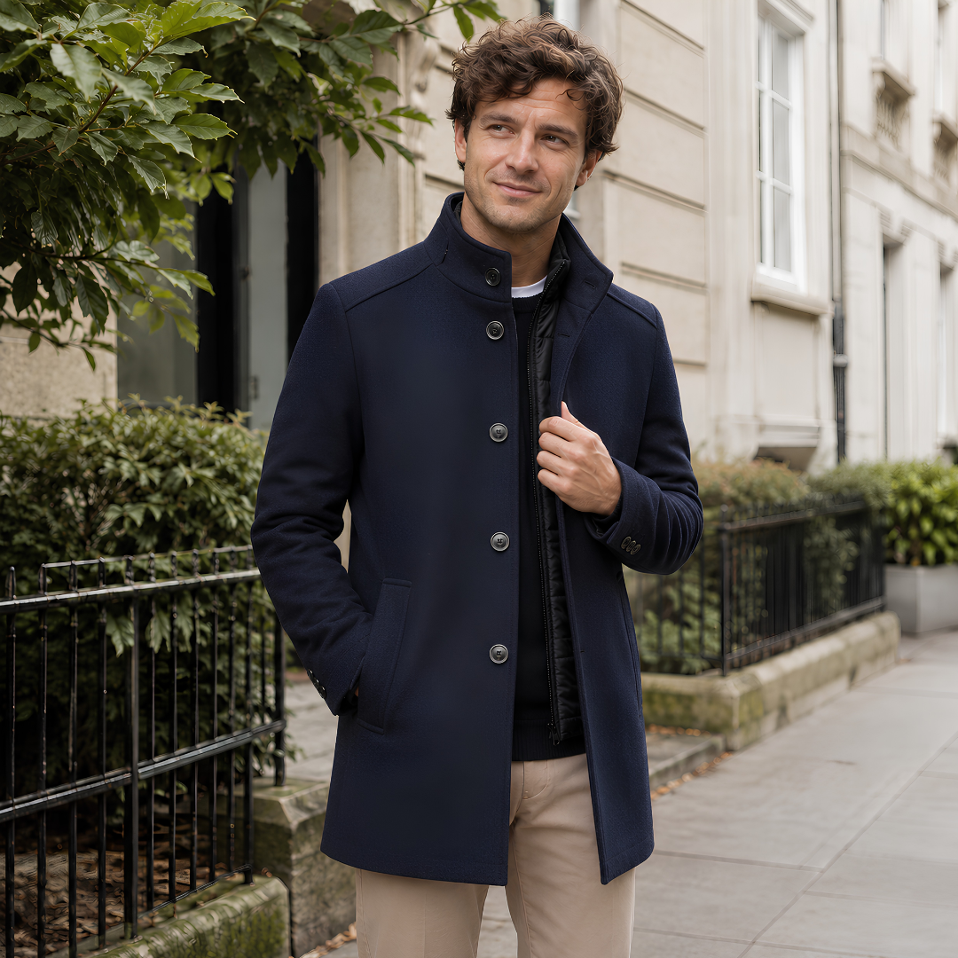 Manteau homme bleu marine mi-long, col montant et boutons visibles aux poignets
