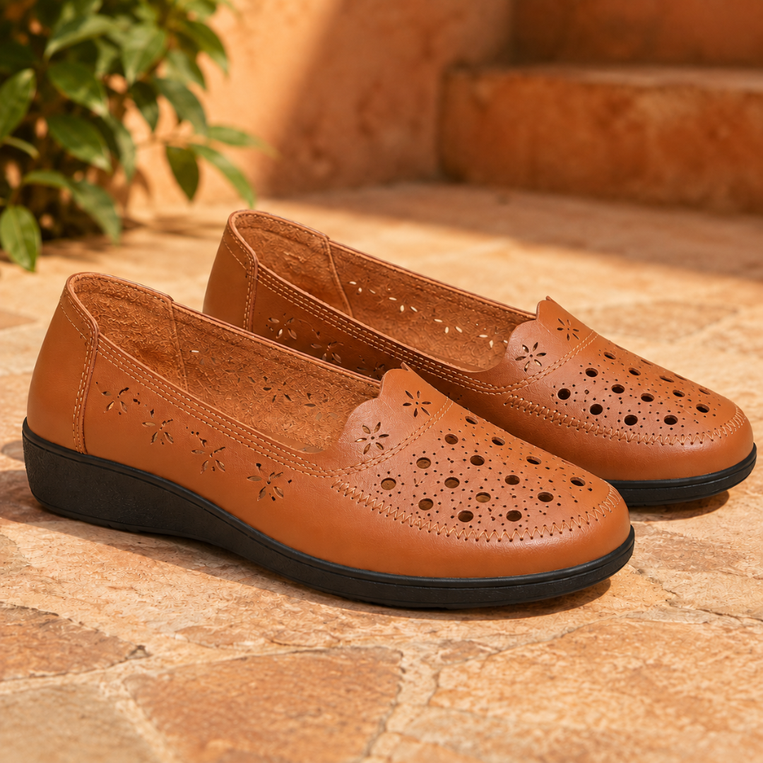 Paire de mocassins marron ajourés de fleurettes, surpiqûres apparentes et semelle noire compensée