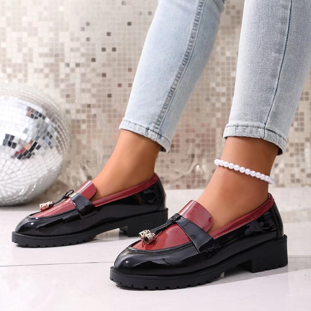 Paire de mocassins femme noirs à empiècement bordeaux brillant, portés avec un pantalon clair