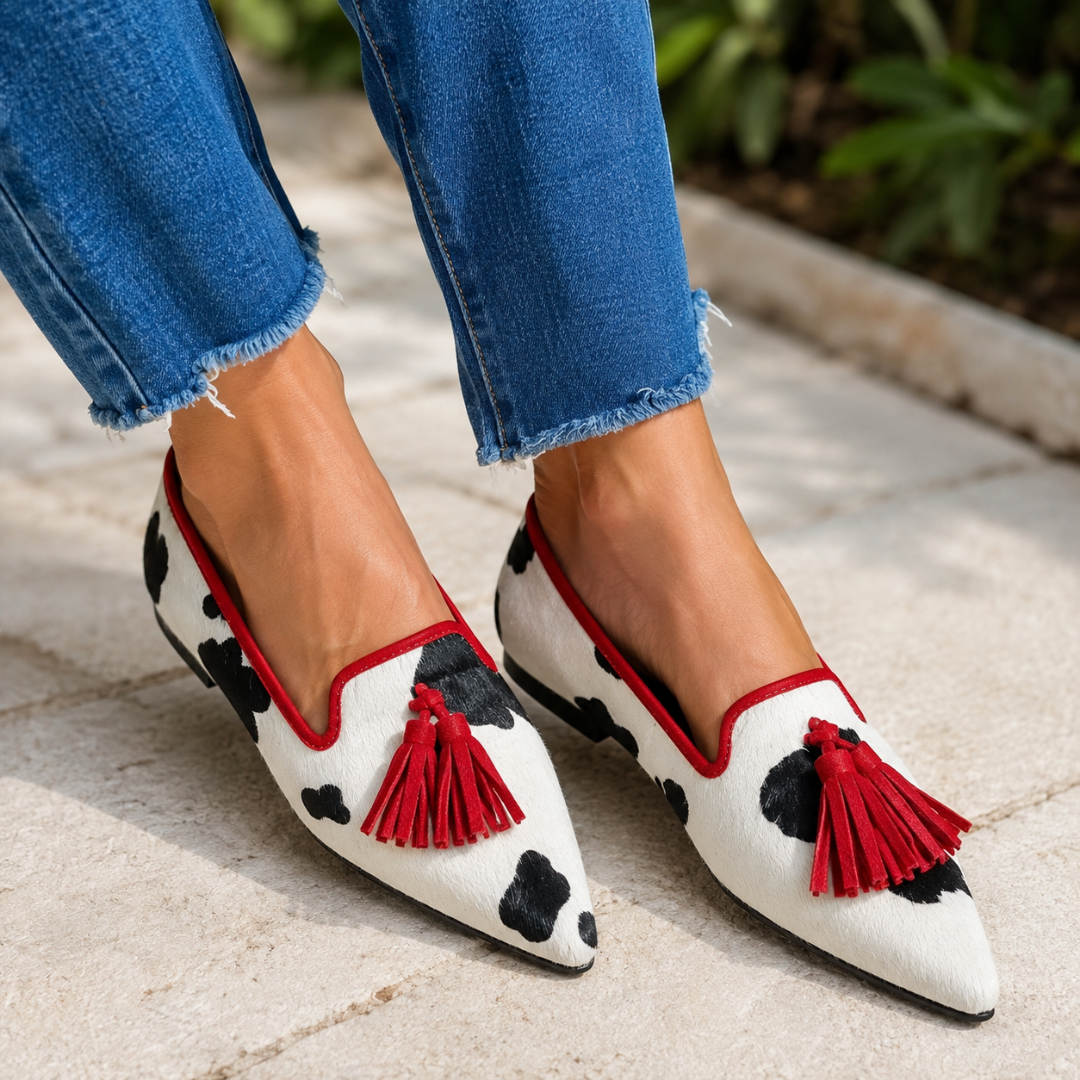 Mocassins blancs tachetés de noir avec liseré et pompons rouges, bout pointu