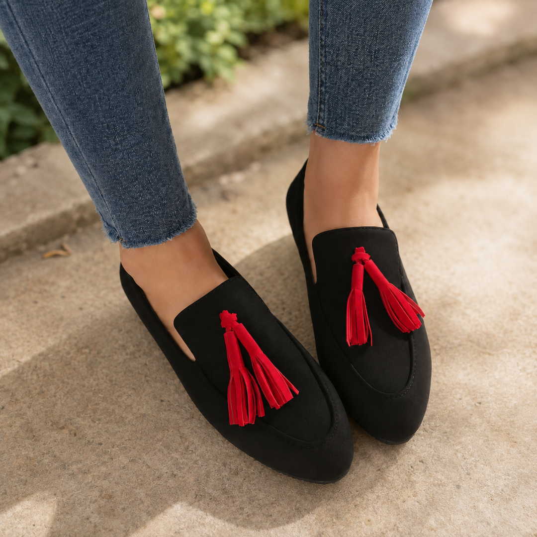 Mocassins femme noirs à pompons rouges portés avec un pantalon bleu