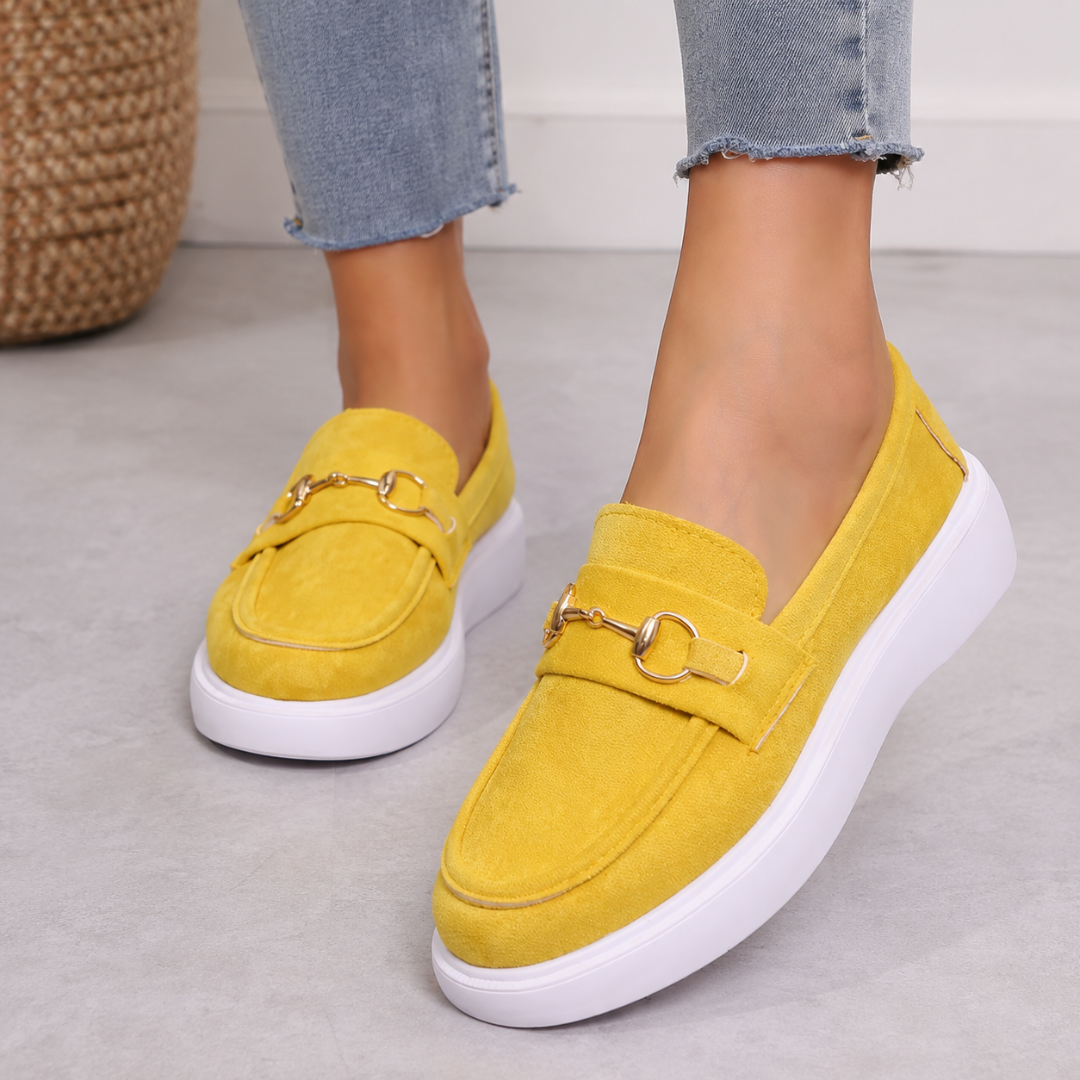 Mocassins jaunes portés avec un pantalon clair, boucle dorée sur la bride avant