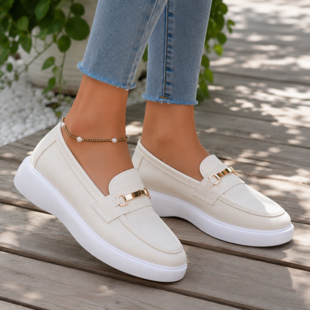 Paire de mocassins blancs à enfiler, dessus arrondi et ornement doré bien visible