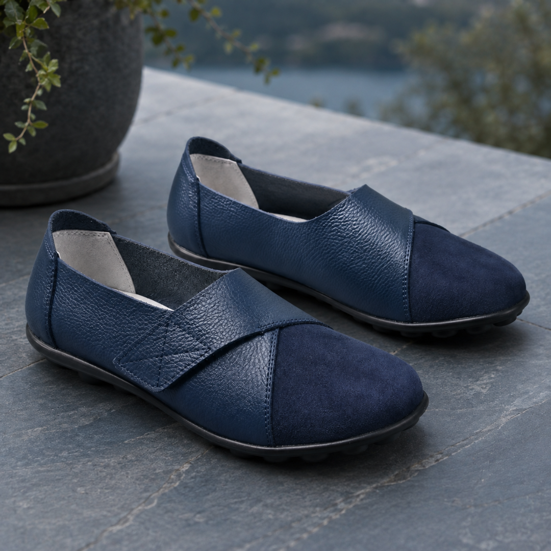 Mocassins femme bleu marine, bride surpiquée en losange, posés sur dalles grises