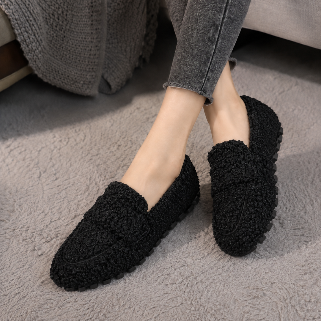 Mocassins noirs à surface bouclée et semelle crantée, portés avec un pantalon gris