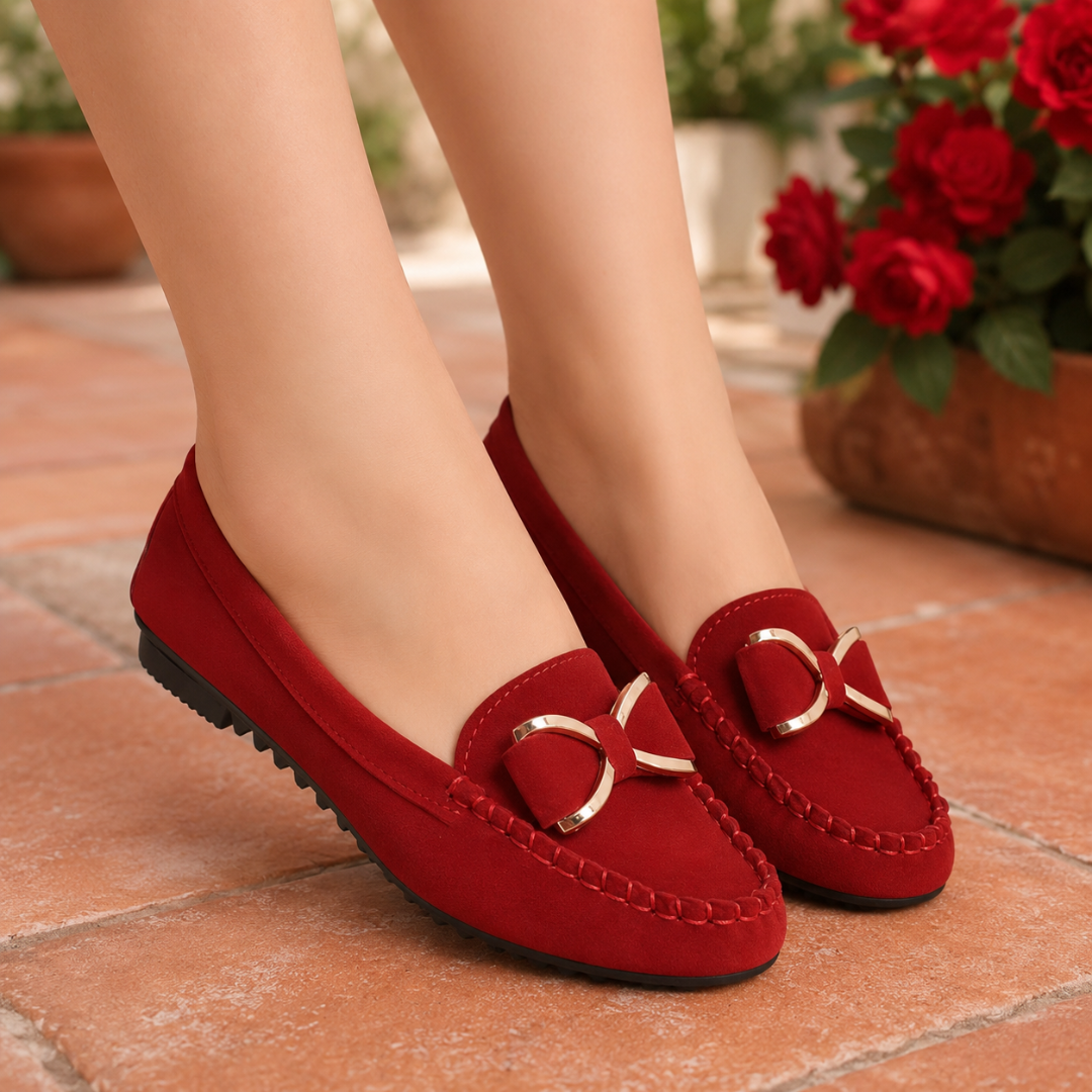 Mocassins rouges à nœud doré portés sur terrasse, semelle crantée noire bien visible