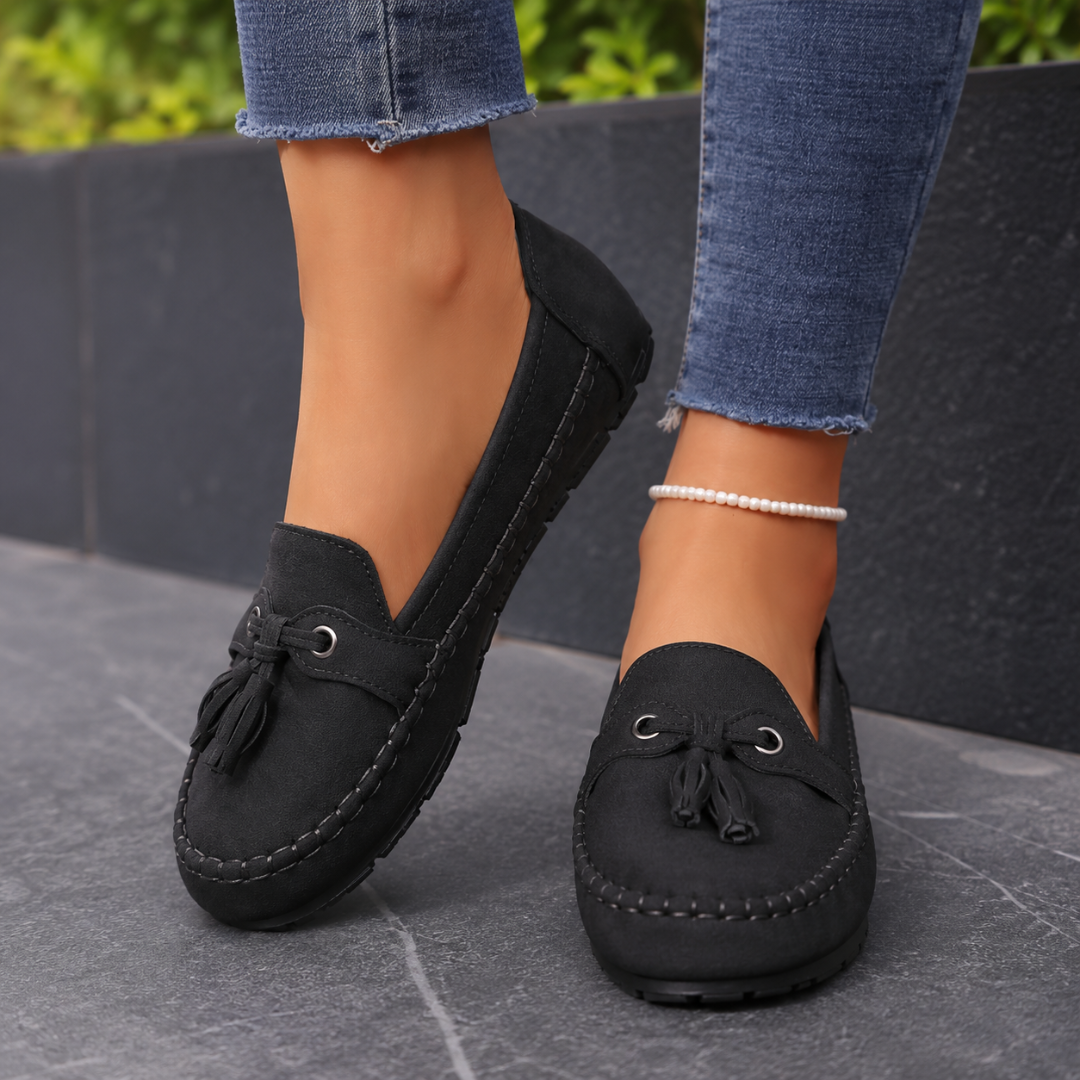 Mocassins femme noirs plats à pompons, coutures discrètes et semelle crantée noire