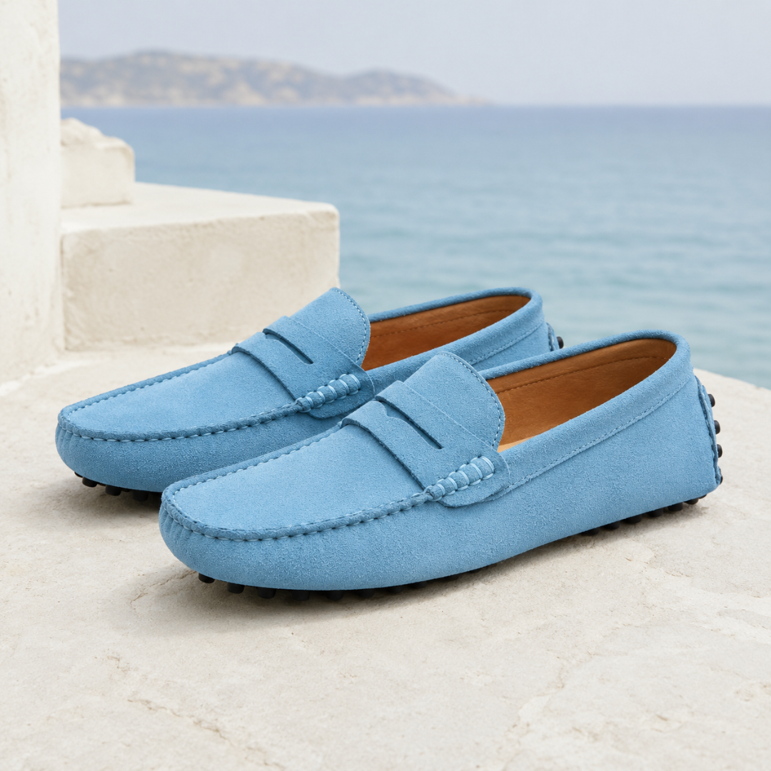 Mocassins homme bleu clair à barrette, intérieur camel, posés face à la mer