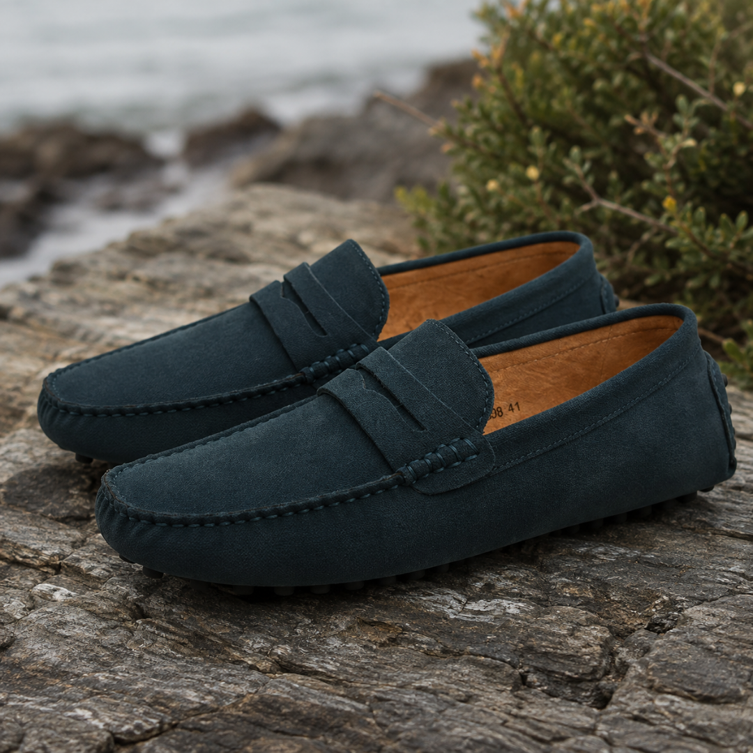 Mocassins homme vert foncé sur une roche, semelle à picots et surpiqûres visibles