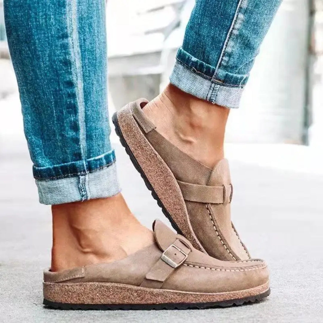 Mules beige portées avec jean retroussé, vue de face légèrement inclinée