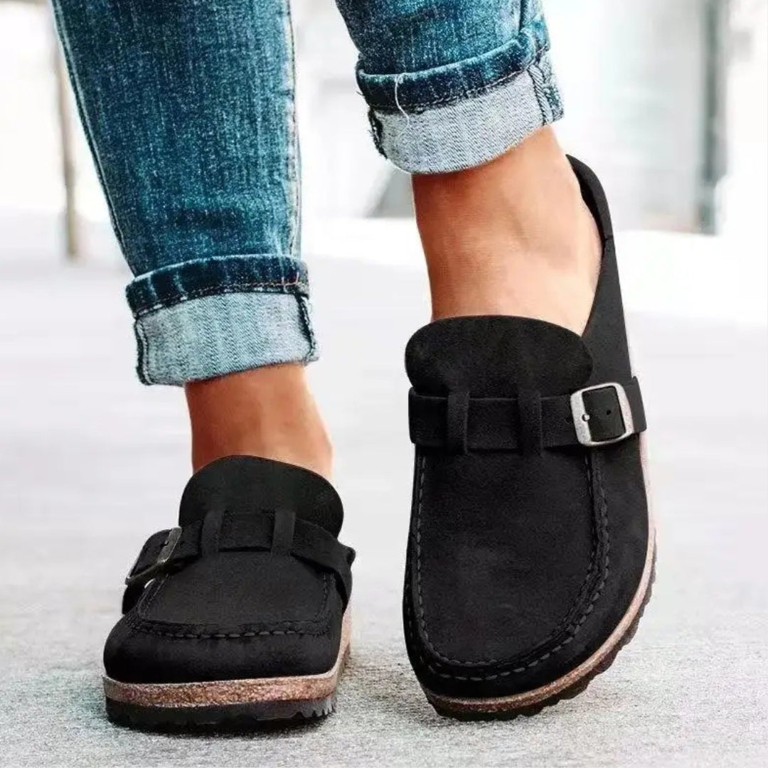 Mules femme noires en suédine avec boucle, portées avec jean foncé