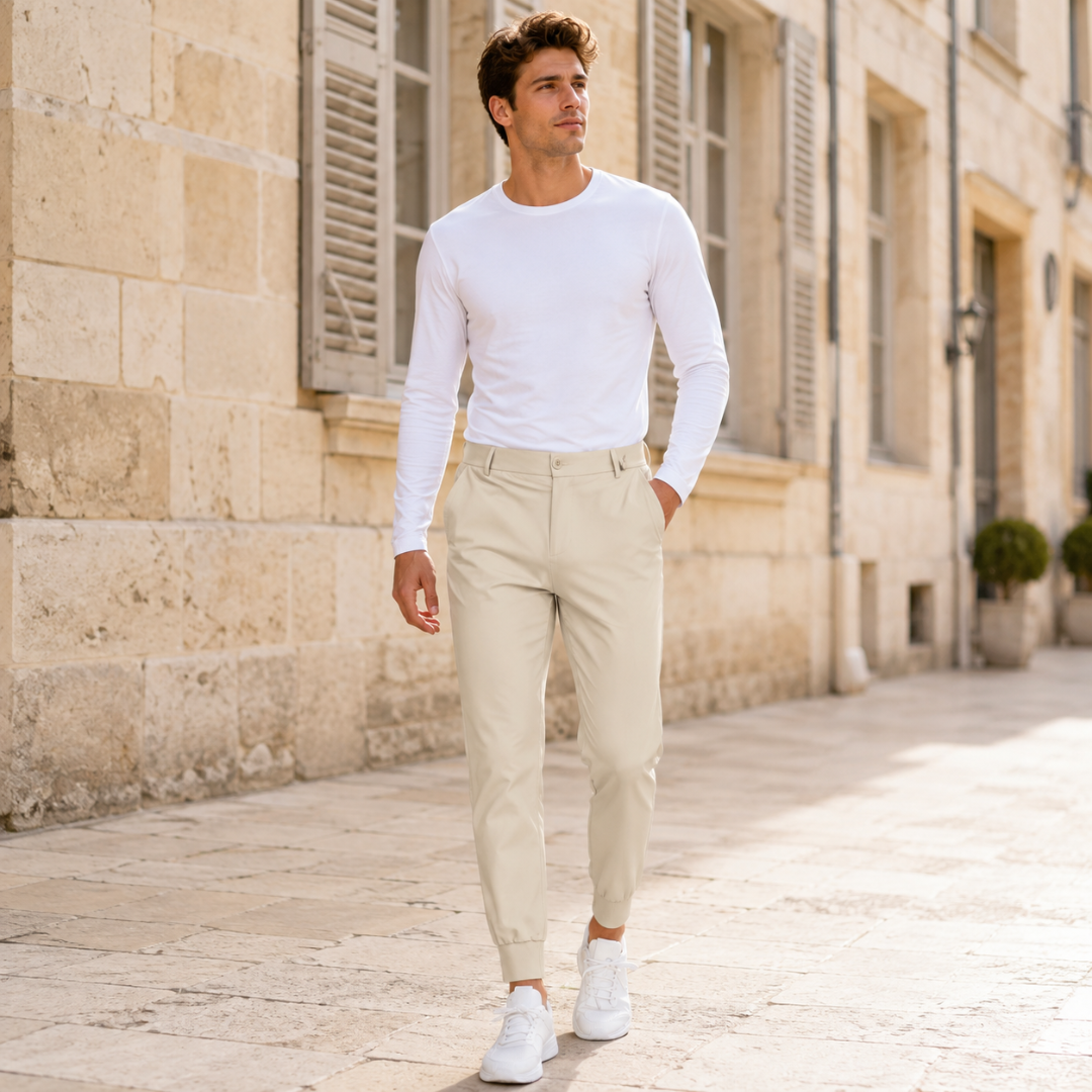 Pantalon jogger beige porté par un homme en marche, silhouette ajustée et taille à passants
