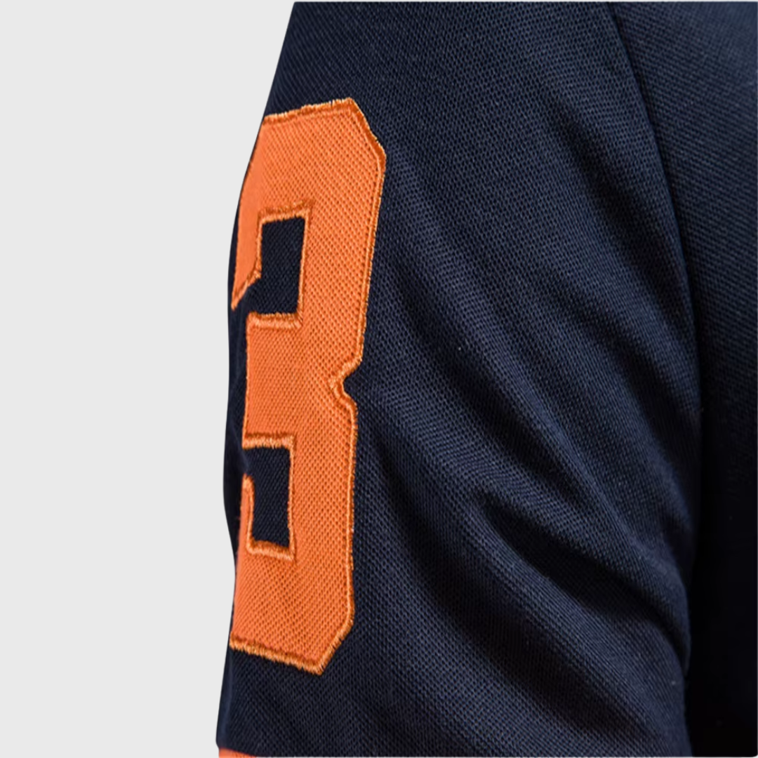 Détail manche polo homme bleu marine avec numéro brodé orange